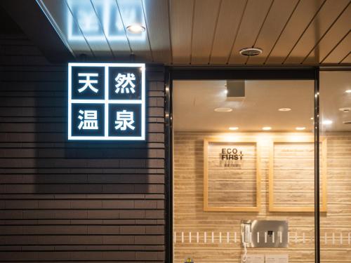 a sign on the side of a building with writing on it at Super Hotel Higashi-Maizuru in Maizuru