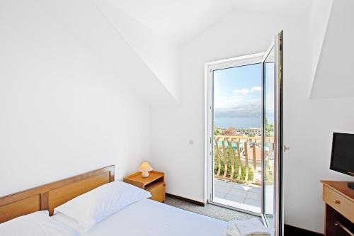 a bedroom with a bed and a large window at Villa Supetar in Supetar
