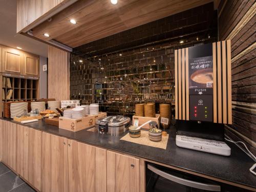 a kitchen with a counter with aasteryasteryasteryasteryasteryasteryasteryasteryastery at Super Hotel Higashi-Maizuru in Maizuru