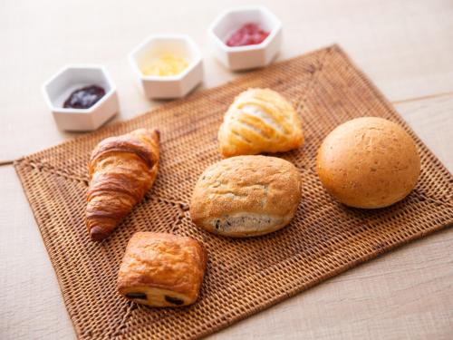 a plate of pastries and croissants on a table at Super Hotel Higashi-Maizuru in Maizuru