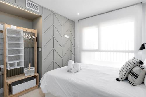 een slaapkamer met een groot wit bed en een raam bij Malagaroom Victoria 43 in Málaga