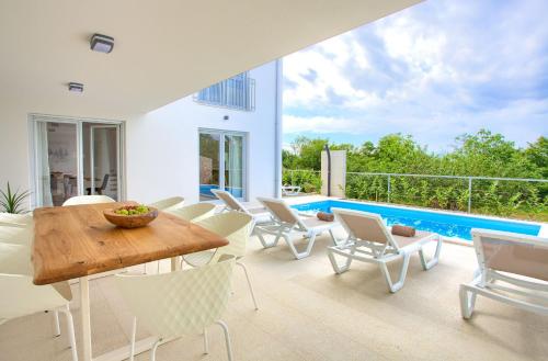 a patio with a table and chairs and a pool at Villa Terra in Županje