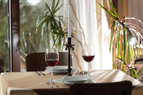 a table with two glasses of red wine and a candle at Hotel Panorama in Panichishte