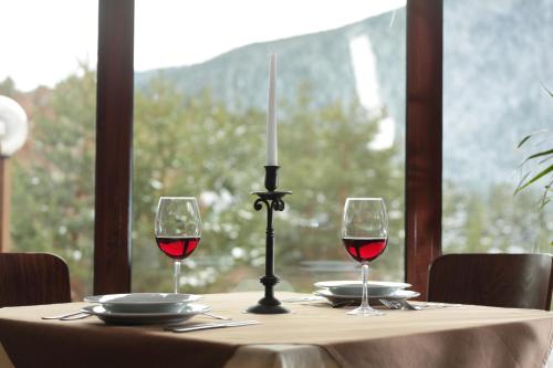 a table with two glasses of red wine and a candle at Hotel Panorama in Panichishte