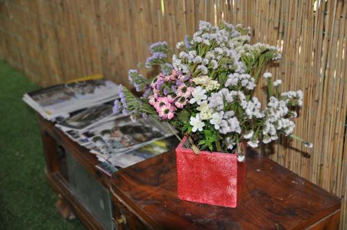 a vase of flowers sitting on top of a table at Rooms Maša in Palić