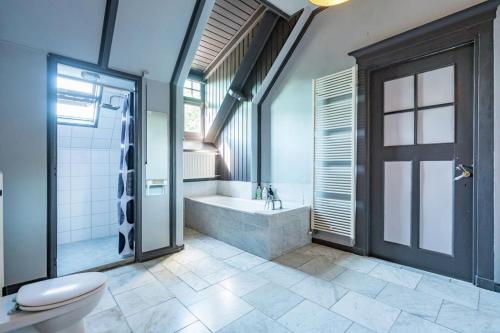 uma casa de banho com uma banheira, um WC e um chuveiro em Seulle State em Sint Jacobiparochie