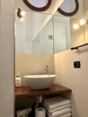 a bathroom with a sink and a mirror and towels at B&B Roomantic & Piscina Idromassaggio in Cefalù