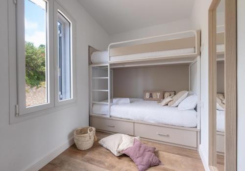 a bedroom with a bunk bed and a window at Casa Concha Apartamentos in Calella de Palafrugell