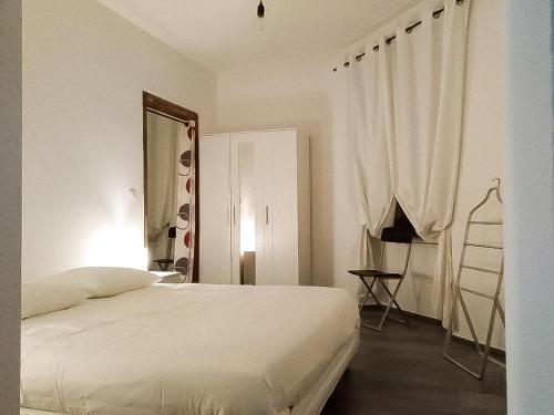 une chambre blanche avec un lit et un miroir dans l'établissement Le Pont Kuss, à Strasbourg