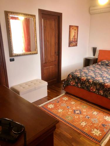a bedroom with a bed and a table and a mirror at B&B Roomantic & Piscina Idromassaggio in Cefalù