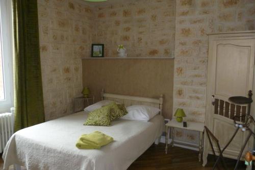 Un dormitorio con una cama con toallas amarillas. en Le Relais de Montigny, en Montigny-le-Gannelon