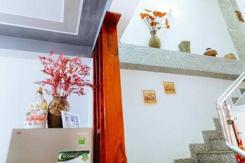 a refrigerator with vases and flowers on top of it at Kota's House Homestay in Hue