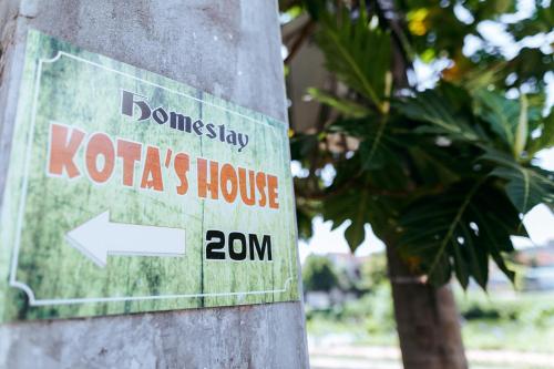 a sign on the side of a tree at Kota's House Homestay in Hue