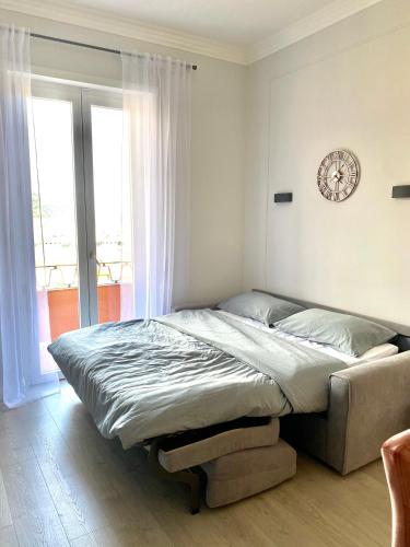 a bed in a bedroom with a clock on the wall at ABCdecor Italia in Imperia
