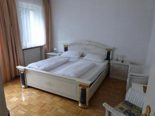 a bedroom with a large white bed and a window at Winzergasthof zum Kellerstübchen in Mehring