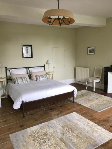 sypialnia z dużym łóżkiem, krzesłem i dywanem w obiekcie L'affable Les cammazes w mieście Les Cammazes
