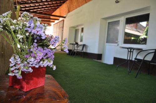 a vase of purple and white flowers on a table at Rooms Maša in Palić