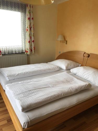 two twin beds in a bedroom with a window at Hotel Garni Haus am Wald in Reifnitz