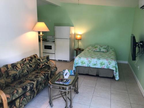Seafarer Key Largo Resort and Beach في كي لارغو: غرفة معيشة مع أريكة وسرير