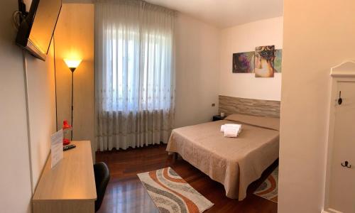 a small room with a bed and a window at B&B La Magnolia in Caprino Veronese