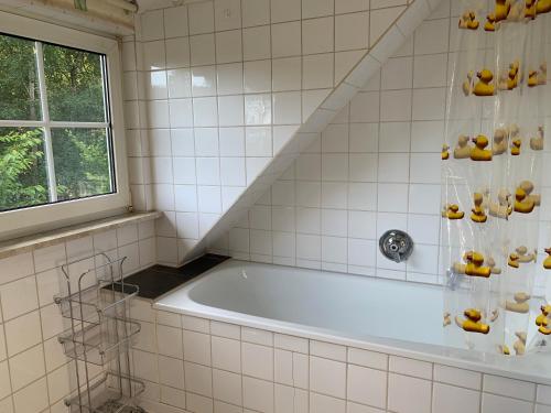 a bathroom with a bath tub and a window at Kleine Ferienvilla in Frankenau in Frankenau