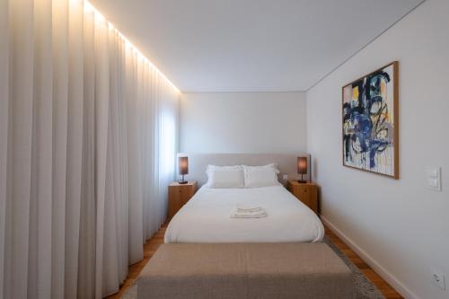 a bedroom with a white bed and a window at Domum in Porto