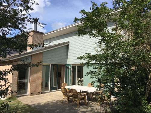 a patio with a table and chairs in front of a house at Sunset Beach House in The Hague