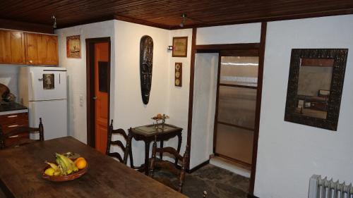 a kitchen with a table with a bowl of fruit on it at The old olive mill house in Aegae