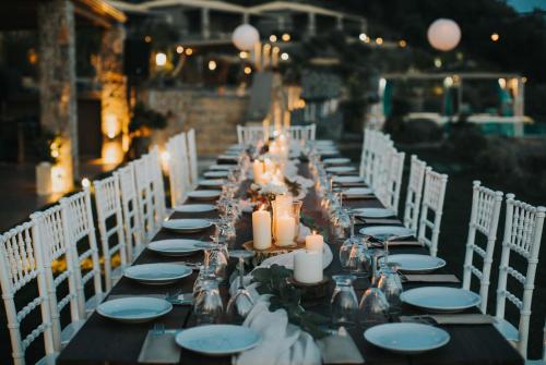 a long table with candles and plates and chairs at Elimnion Resort in Khronia