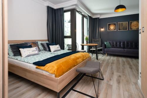 een slaapkamer met een bed en een woonkamer bij Grey Horse Apartment premium in Gdańsk
