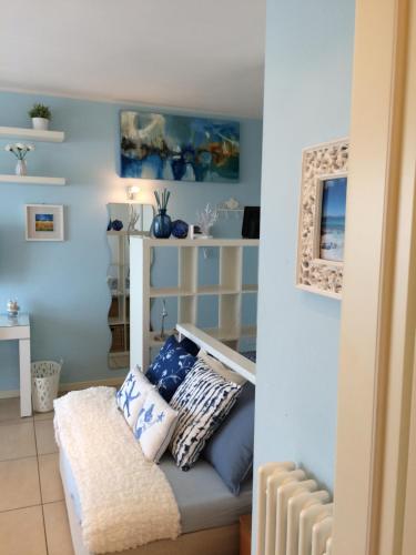 Habitación con paredes azules y banco con almohadas. en La Marina, en Rímini