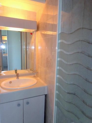 une salle de bain avec un lavabo et une douche dans l'établissement APPT 1 CHAMBRE QUARTIER DES PLAGES, à Sète