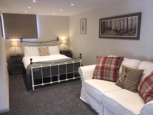 a living room with a bed and a couch at Harepath Farm Cottages 2 in Exeter