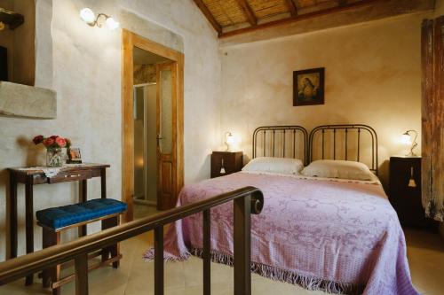 a bedroom with a bed with a pink bedspread at Borgoterra in Martano