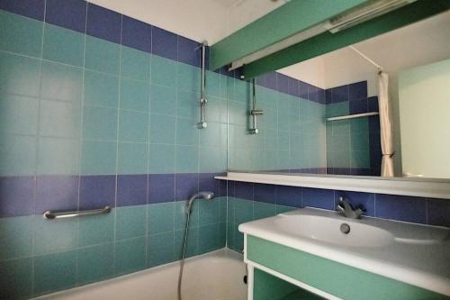 La salle de bains est pourvue d'un lavabo, d'une baignoire et d'un miroir. dans l'établissement Antibes les Pins 2 Pièces vue mer piscine parking, à Antibes
