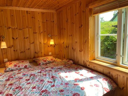 Cama en habitación de madera con ventana en Golden Seaside Villa en Kärdla