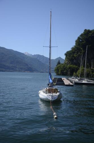 a sailboat is docked in a large body of water at AnMa Cottages The Secret Garden in Pianello Del Lario