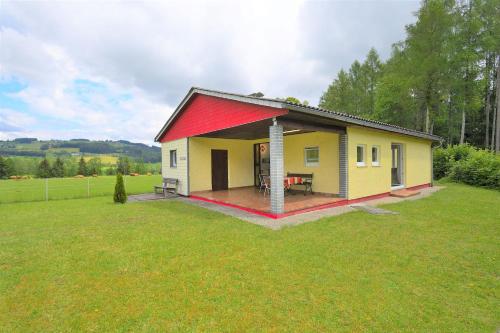 a small yellow house with a red roof at Ferienhaus am Traunsee mit Bergsicht in Traunkirchen
