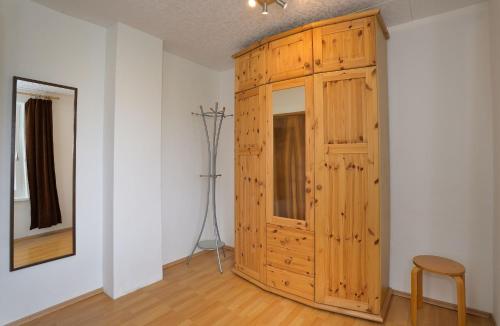 a large wooden cabinet in a room with a chair at Ferienhaus am Traunsee mit Bergsicht in Traunkirchen