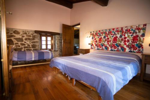ein Schlafzimmer mit einem großen Bett und einer Steinwand in der Unterkunft Agriturismo Il Corniolo in Castiglione di Garfagnana