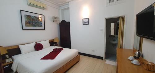 a bedroom with a white bed with red bows on it at Hanoi Win Hotel & Travel in Hanoi