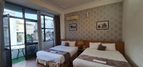 a hotel room with two beds and a window at Hanoi Win Hotel & Travel in Hanoi
