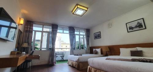 a hotel room with two beds and a window at Hanoi Win Hotel & Travel in Hanoi