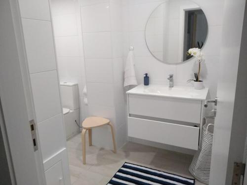 a white bathroom with a sink and a mirror at Apartamentos Areia e Mar Sul in Vila Praia de Âncora