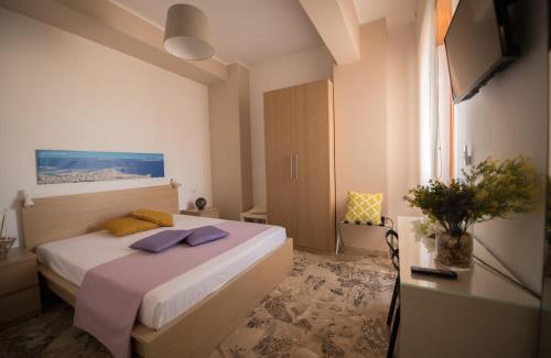 トラーパニにあるSale e Sabbiaのベッドルーム1室(紫色のタオルが付いたベッド1台付)