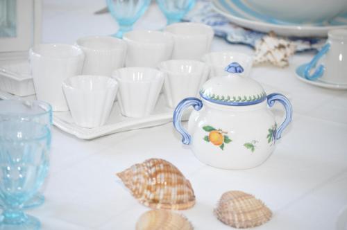 a table with seashells and a tea pot and glasses at I Citri in Taranto