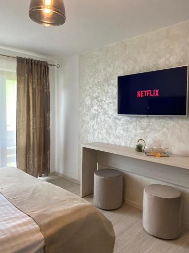 a bedroom with a bed and a television on the wall at Pensiunea Maria in Durau