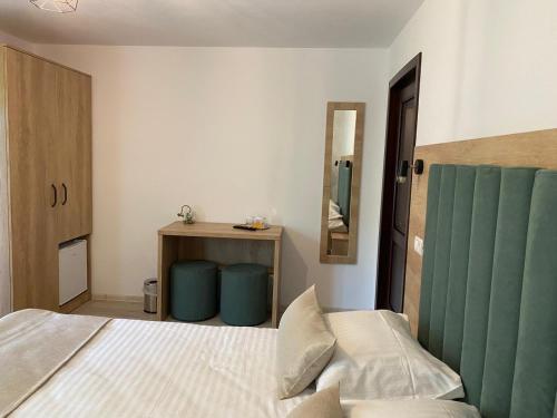 a bedroom with a bed and a table with a mirror at Pensiunea Maria in Durau