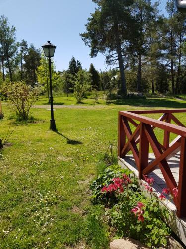 a wooden bridge in a park with flowers and a street light at Södra Kärr 4 in Gränna