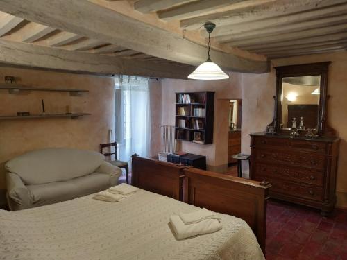 1 dormitorio con cama, silla y vestidor en Casa Pizzinelli, en San Casciano dei Bagni